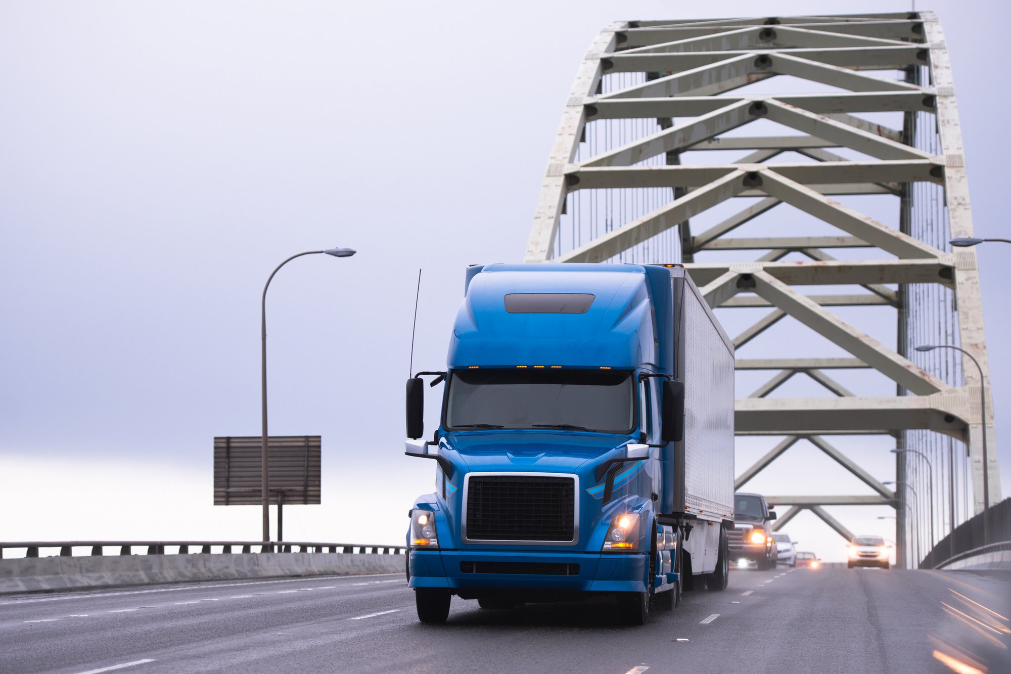 blue semi truck on bridge